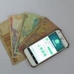 white Android smartphone beside banknotes