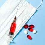 Syringe and Pills on Blue Background